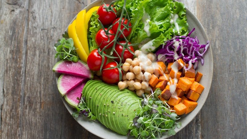Ciotola colorata di verdure fresche, legumi e cereali — esempio di piatto saziante