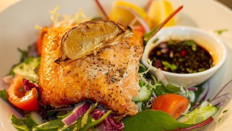 Fonti proteiche su un piatto — salmone, verdure e insalata mista